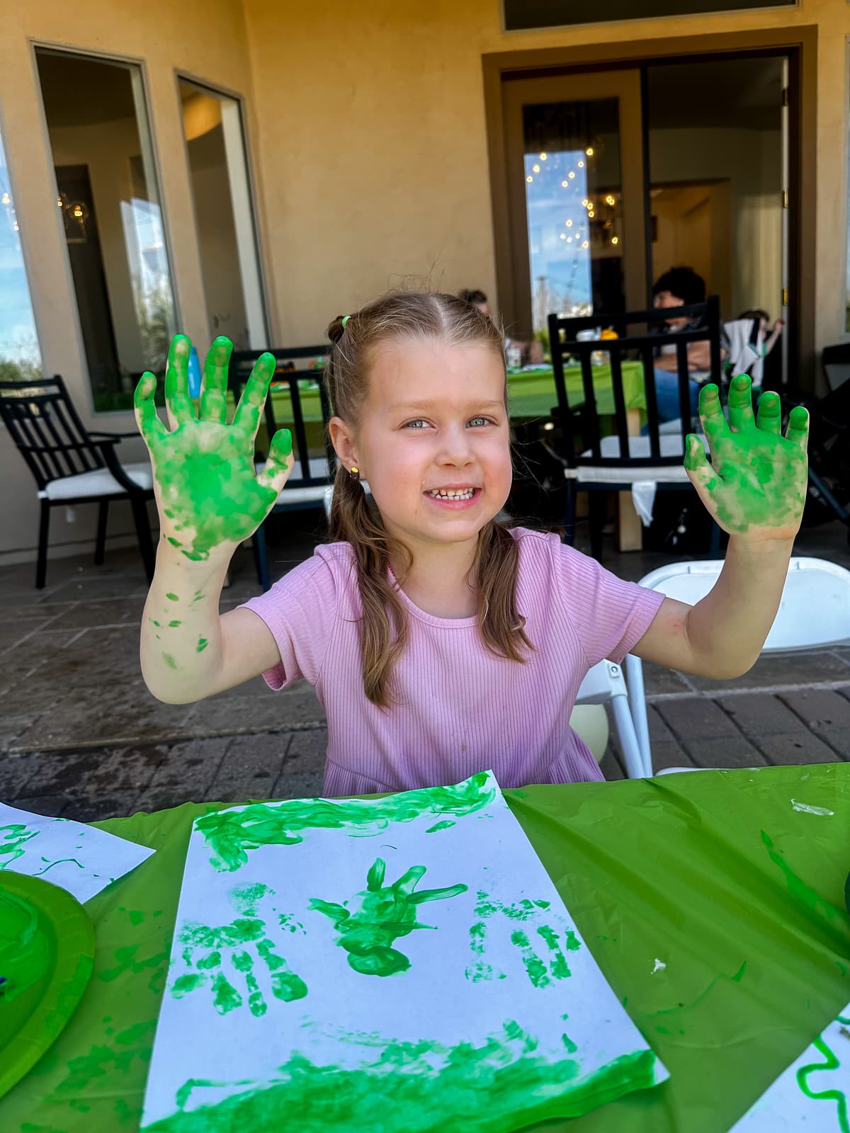 Little girl with green paint on her hands from shamrock stamping craft