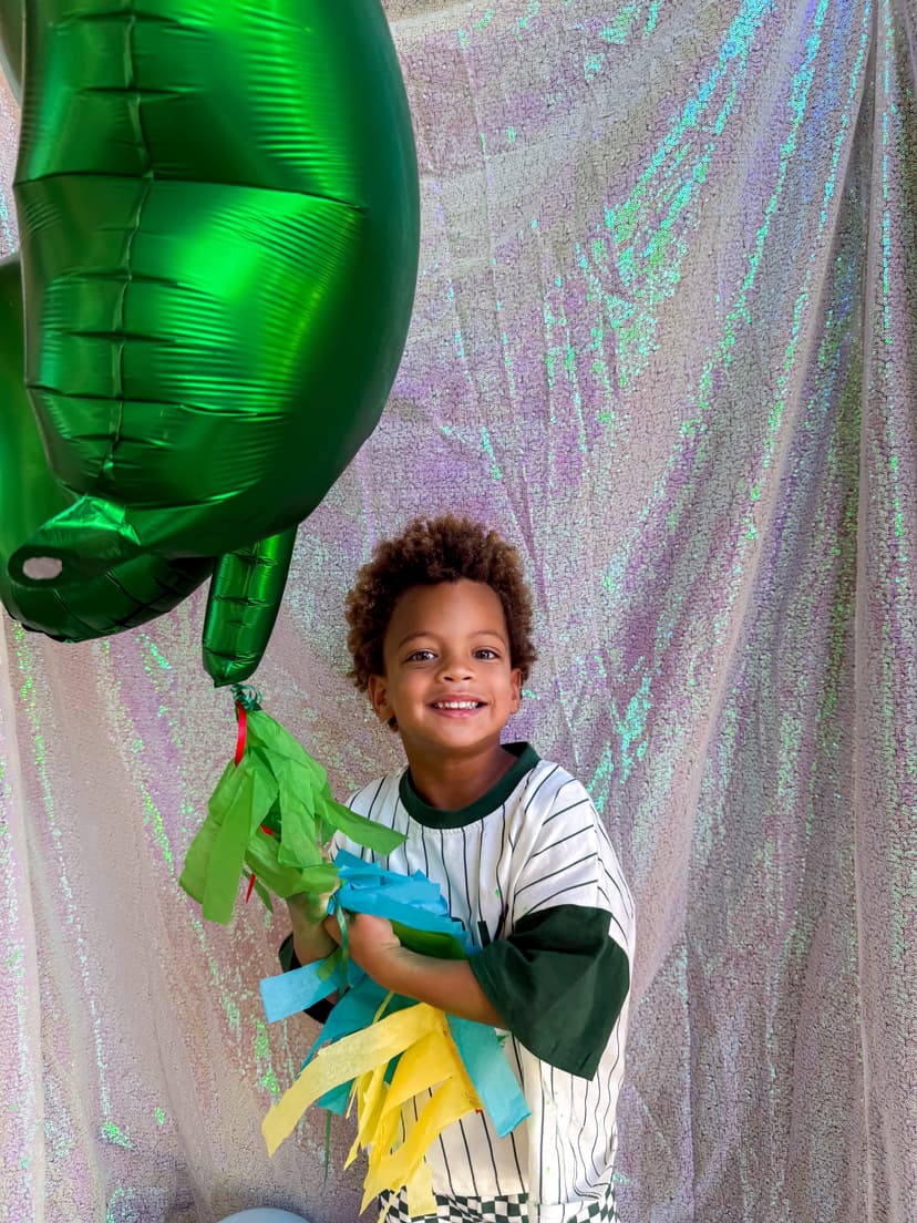 Happy child with green balloon at playdate
