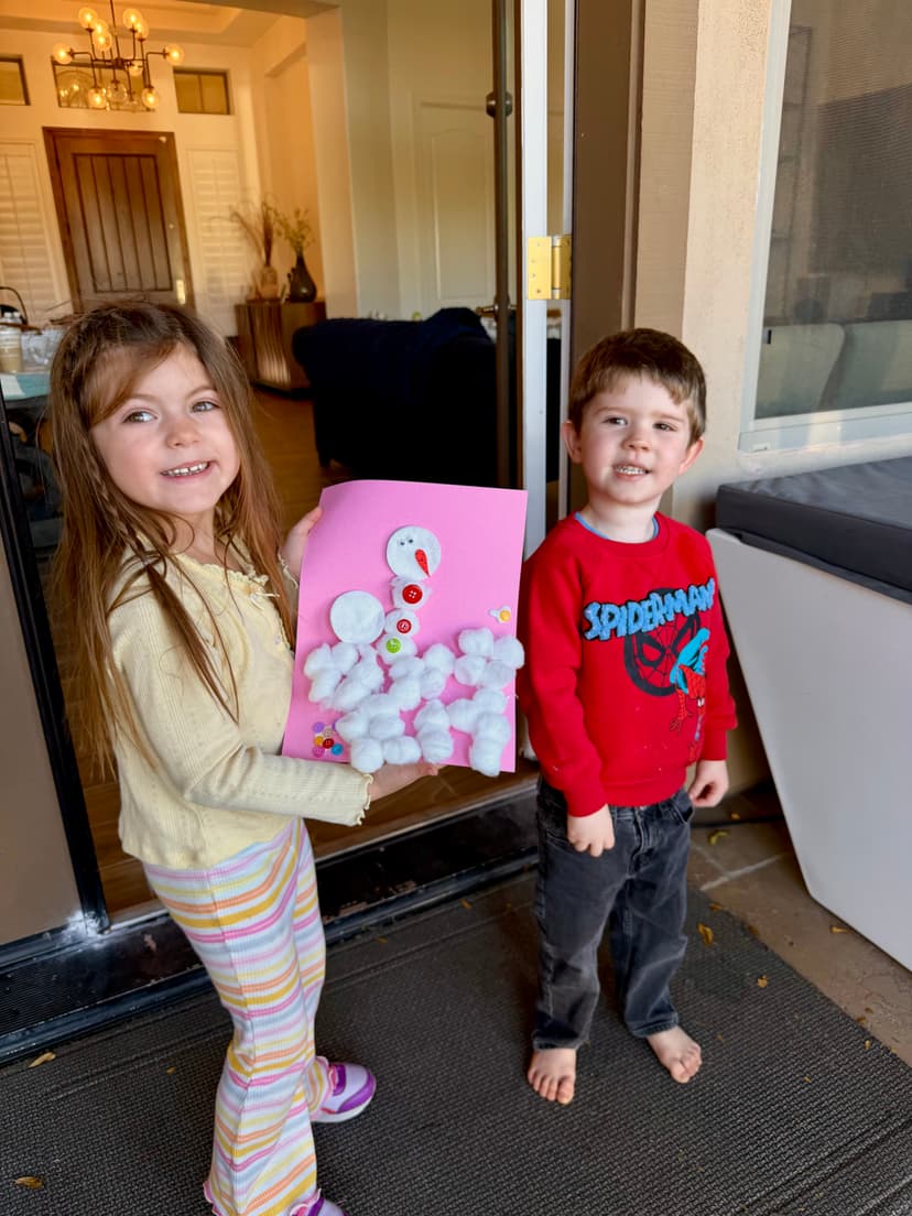 Kids showing off their cotton ball snowman craft